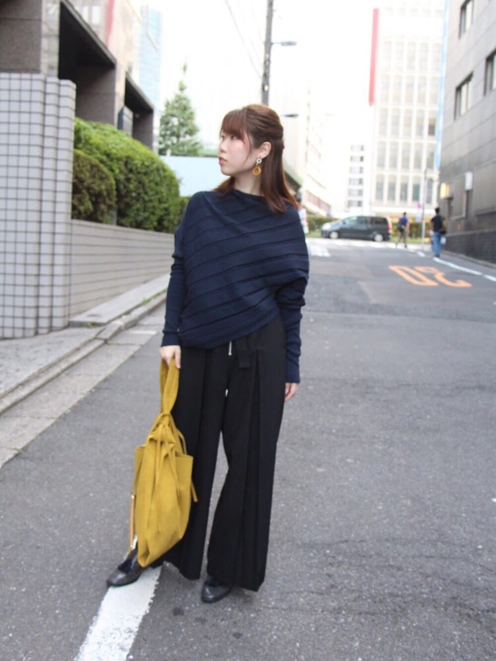 ブルー系のニット/セーター、ブラック系のその他パンツ、イエロー系のバッグを着用したレディースの夏コーディネートの1枚目の写真