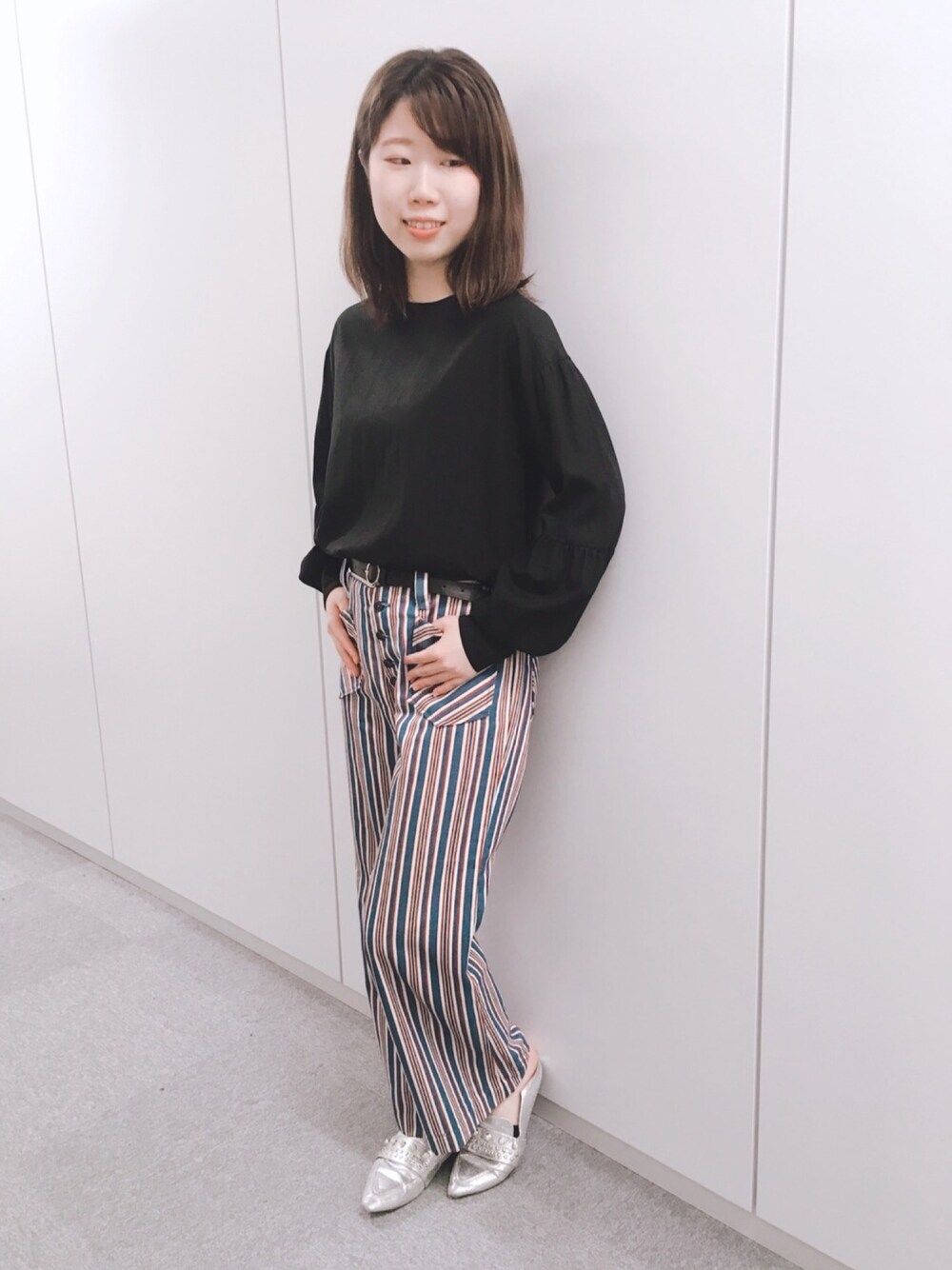 ブラック系のシャツ/ブラウス、ブルー系のパンツを着用したレディースの秋コーディネートの1枚目の写真