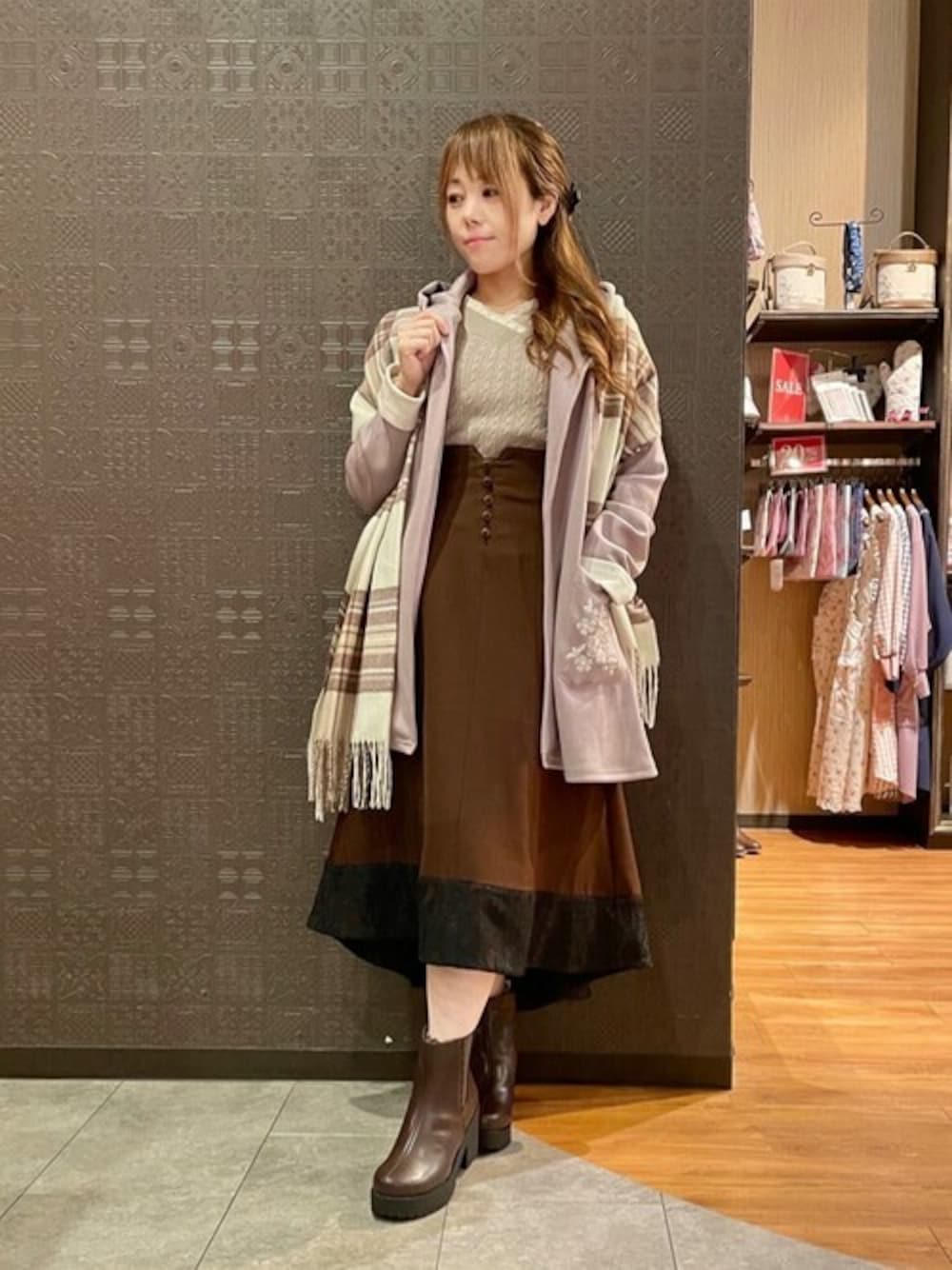 パープル系のカーディガン/ボレロ、ブラウン系のニット/セーター、ブラウン系のスカートを着用したレディースの秋コーディネートの1枚目の写真