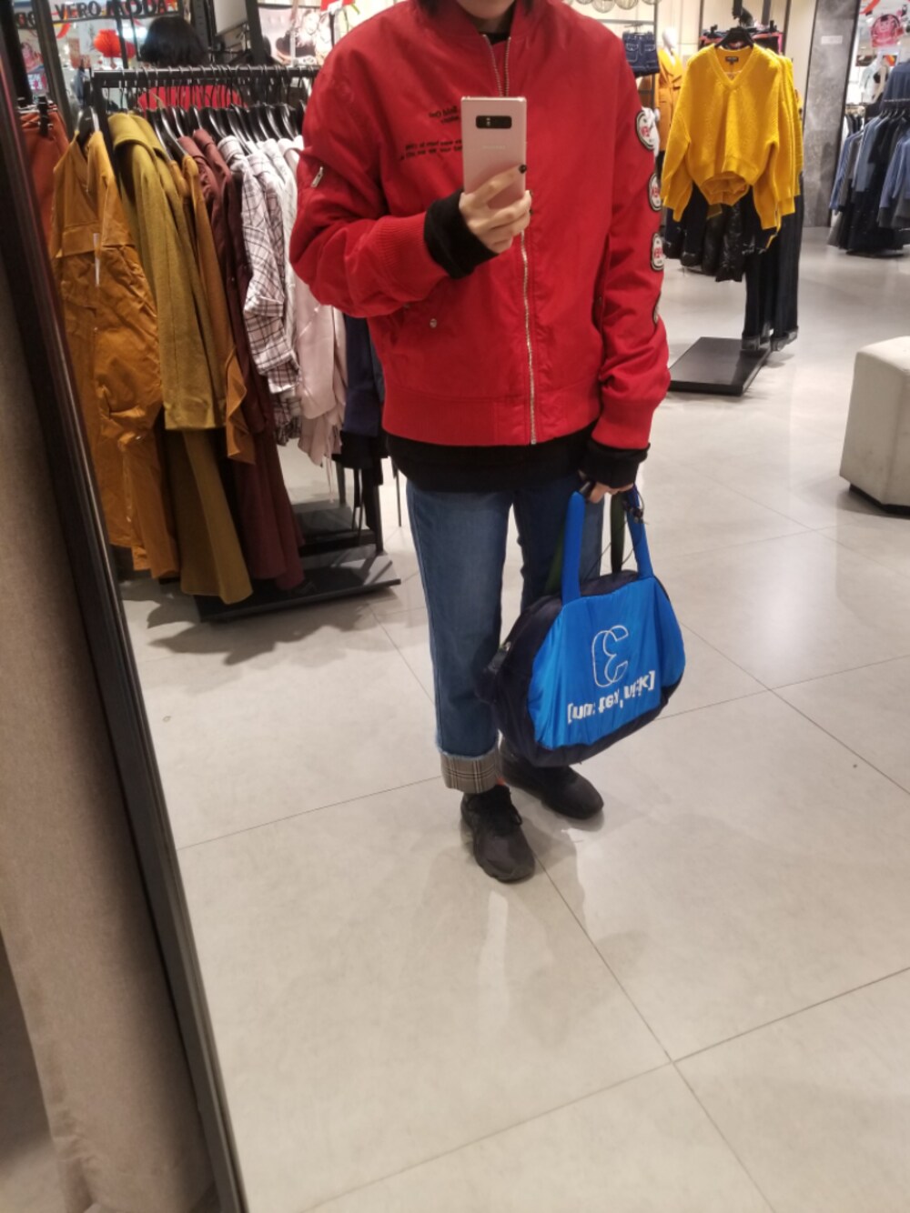 レッド系のライダースジャケットを着用したレディースの冬コーディネートの1枚目の写真