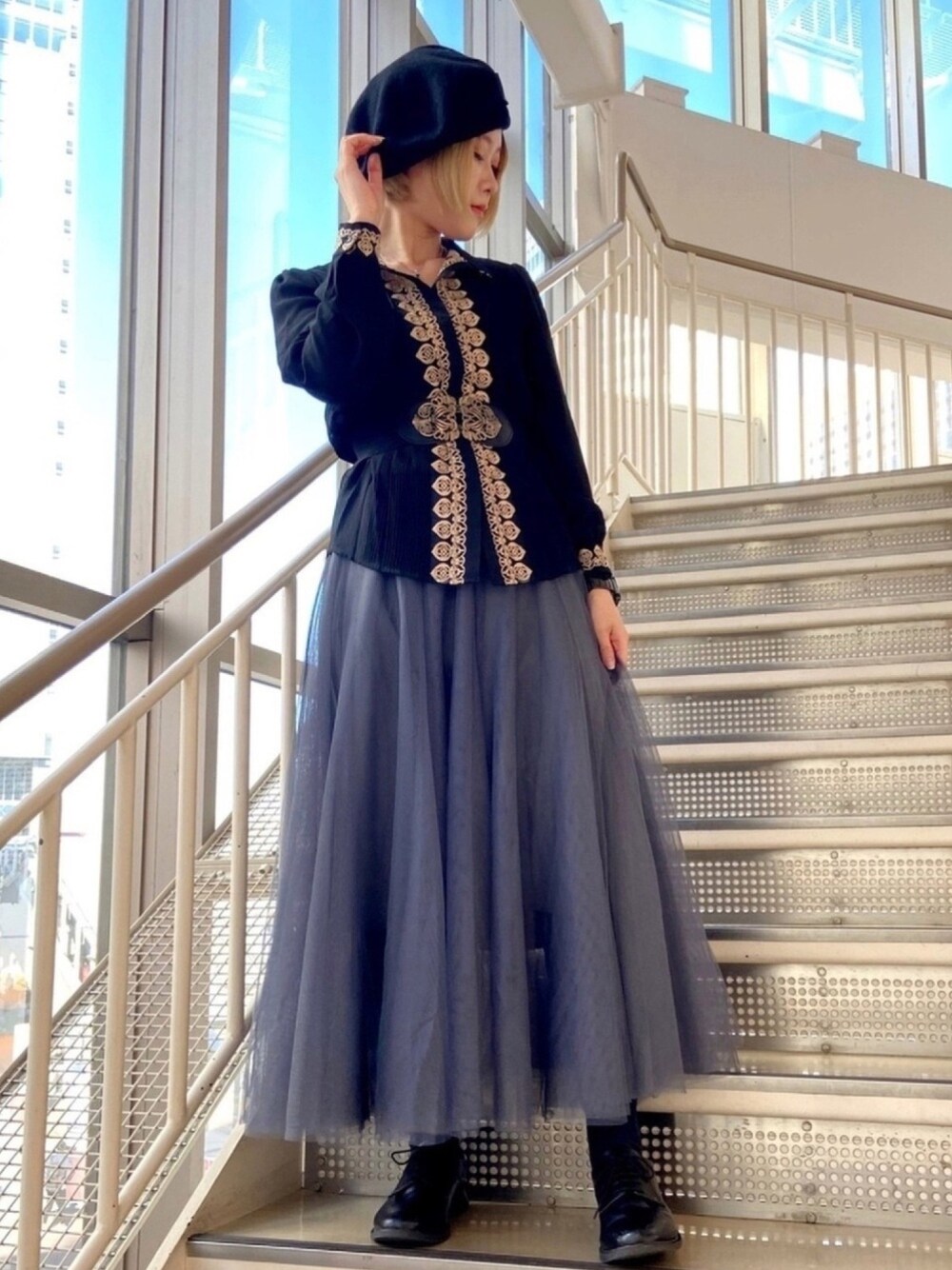 グレー系のスカート、ブラック系のシャツ/ブラウス、ブラック系のシューズを着用したレディースの冬コーディネートの1枚目の写真