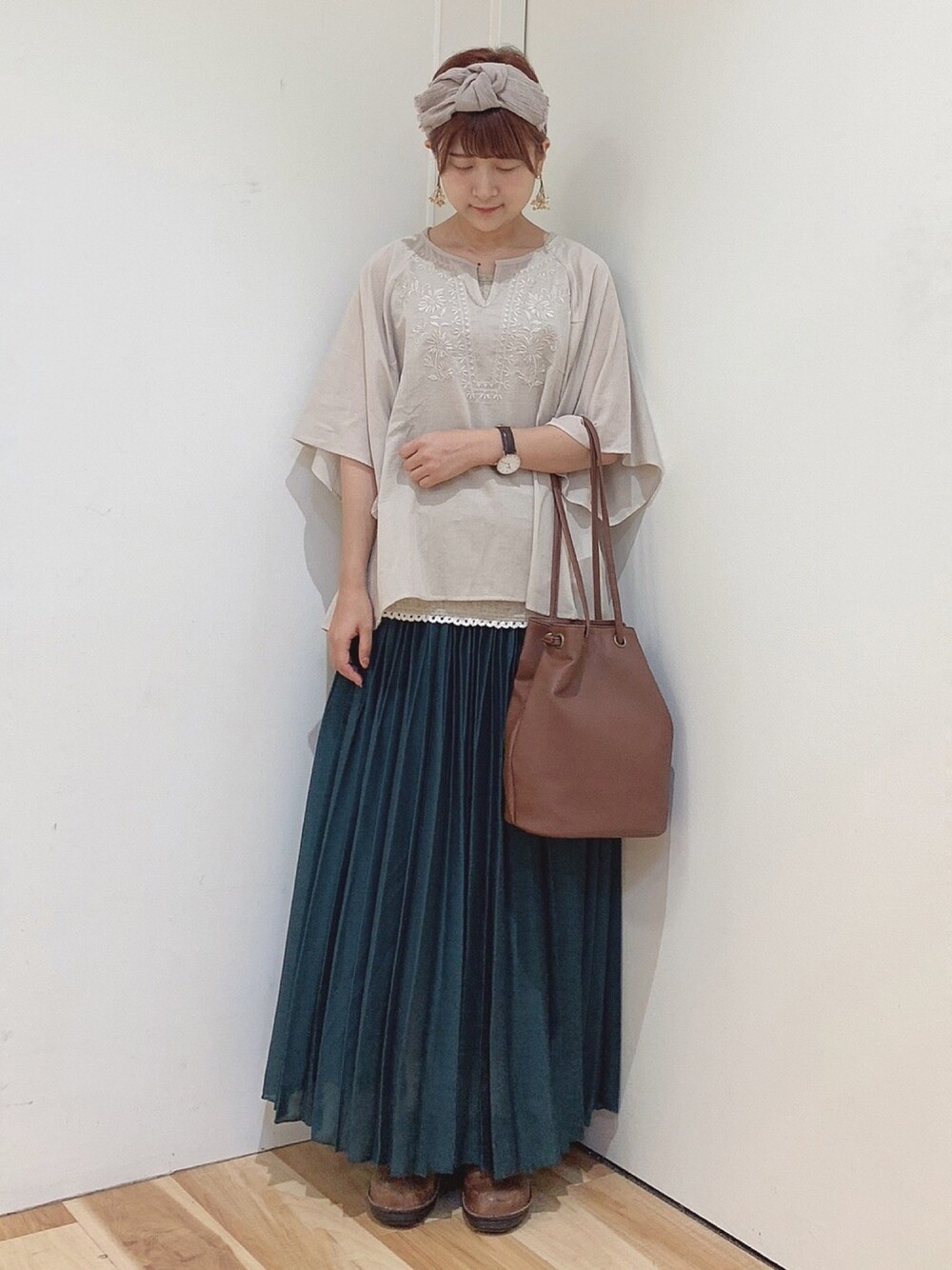 ブラウン系のショルダーバッグ、ホワイト系のシャツ/ブラウス、ベージュ系のTシャツ/カットソーを着用したレディースの夏コーディネートの1枚目の写真