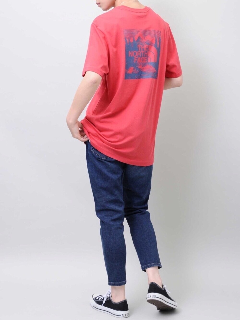 レッド系のTシャツ/カットソー、ブルー系のデニムパンツ、ブラック系のスニーカーを着用したレディースの夏コーディネートの1枚目の写真