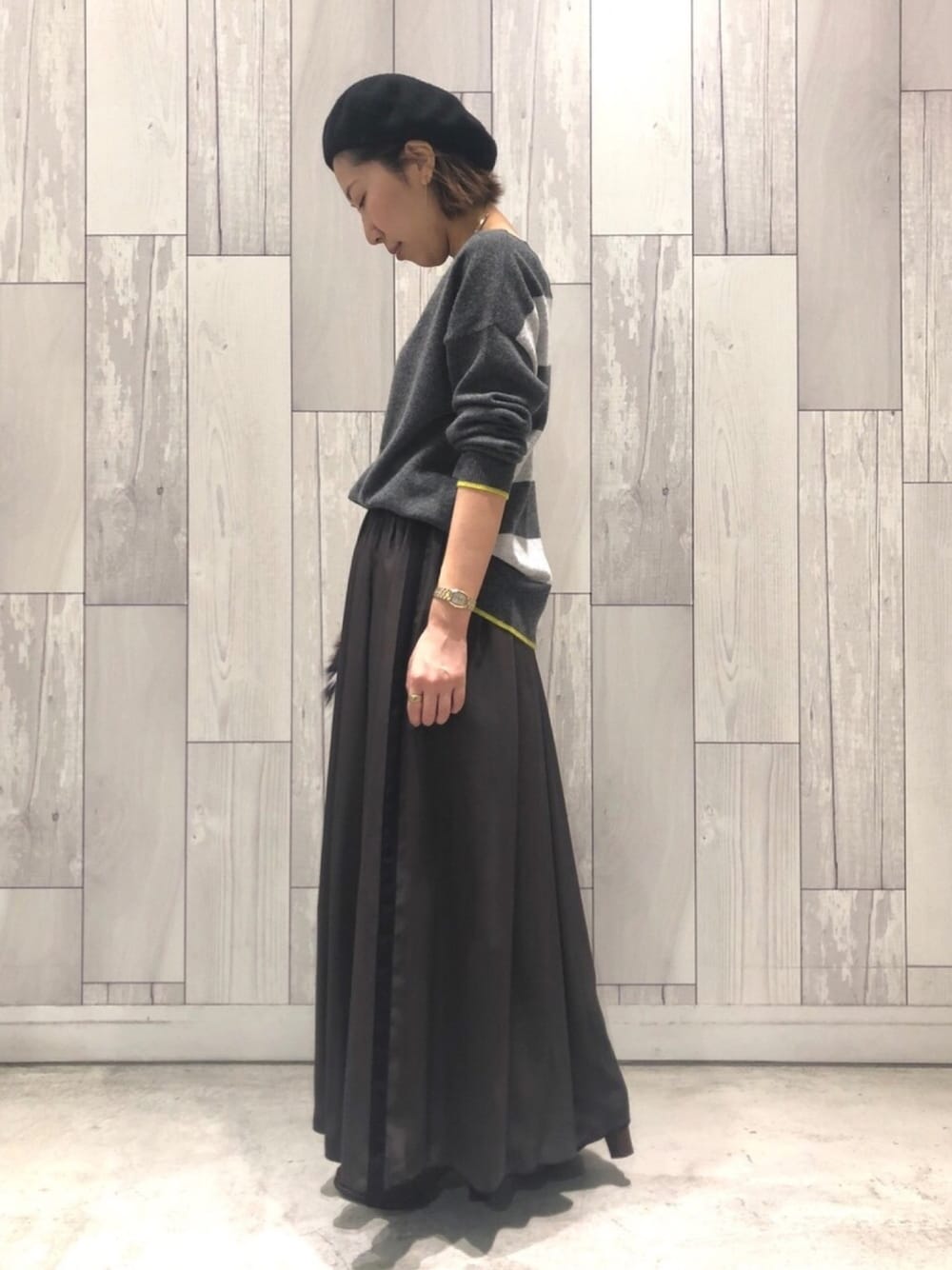 グレー系のニット/セーター、その他のショルダーバッグ、グリーン系のスカートを着用したレディースの秋コーディネートの1枚目の写真