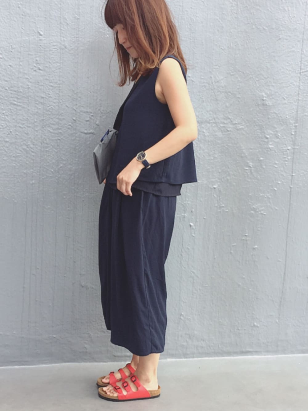 ゴールド系のアナログ腕時計を着用したレディースの夏コーディネートの1枚目の写真