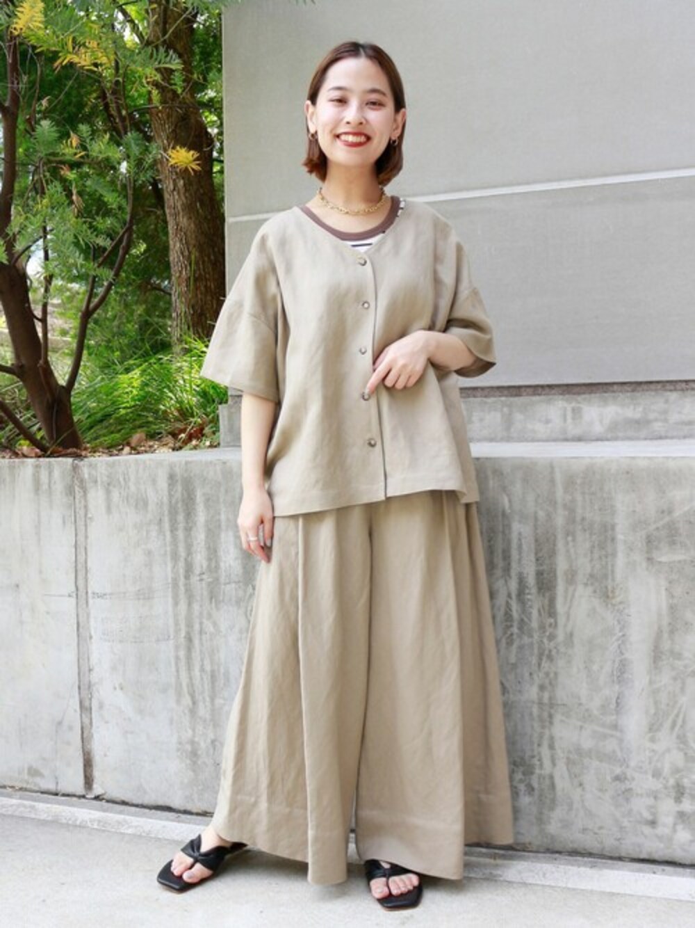 ベージュ系のシャツ/ブラウス、ベージュ系のその他パンツ、グリーン系のタンクトップを着用したレディースの春コーディネートの1枚目の写真