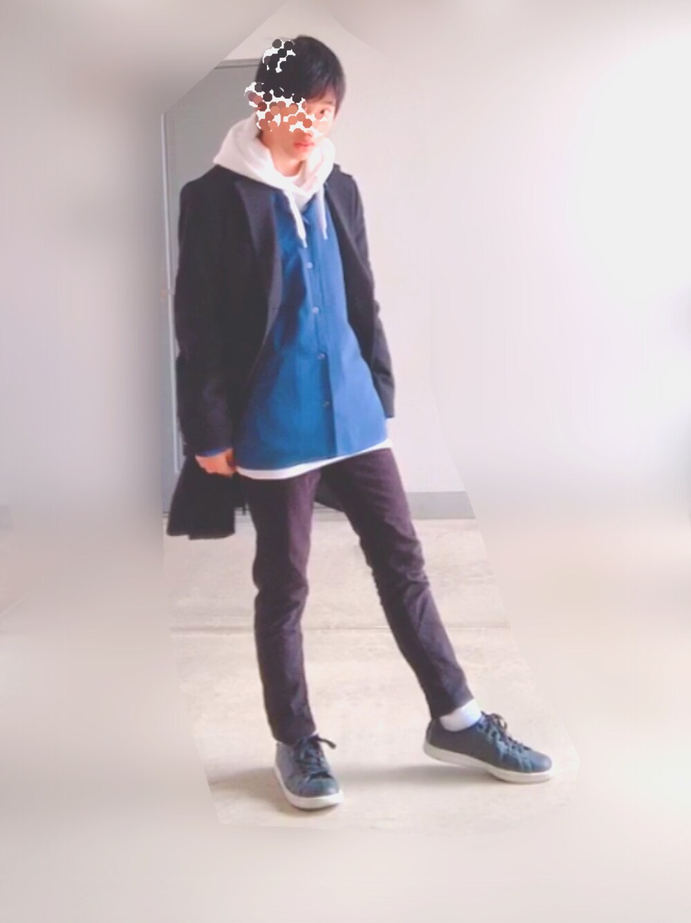 ブラック系のスニーカー、ブラック系のデニムパンツ、ホワイト系のパーカーを着用したメンズの冬コーディネートの1枚目の写真