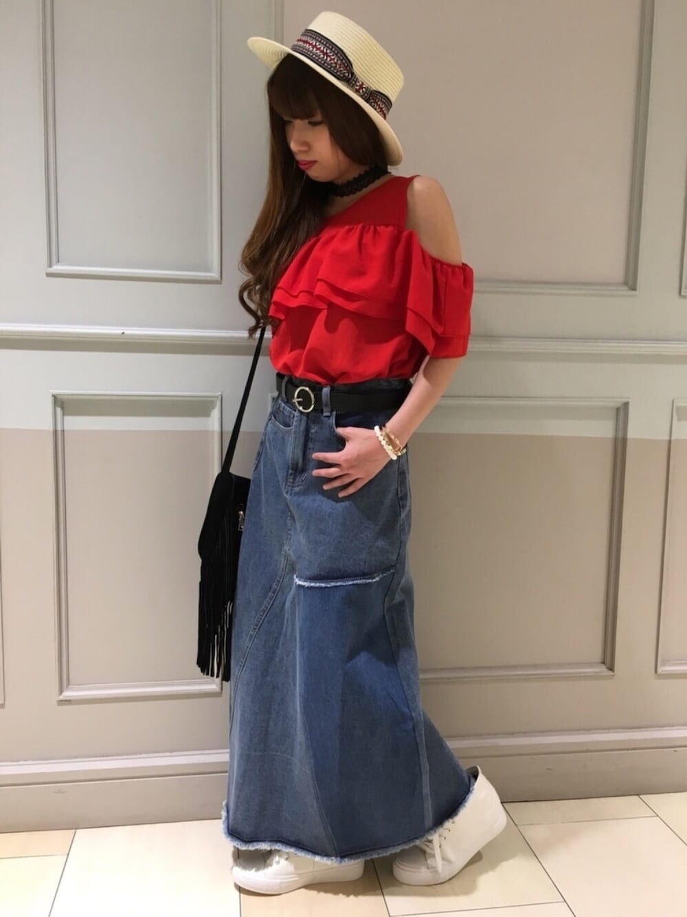 ブルー系のスカート、レッド系のその他トップス、ブラック系のベルトを着用したレディースの春コーディネートの1枚目の写真