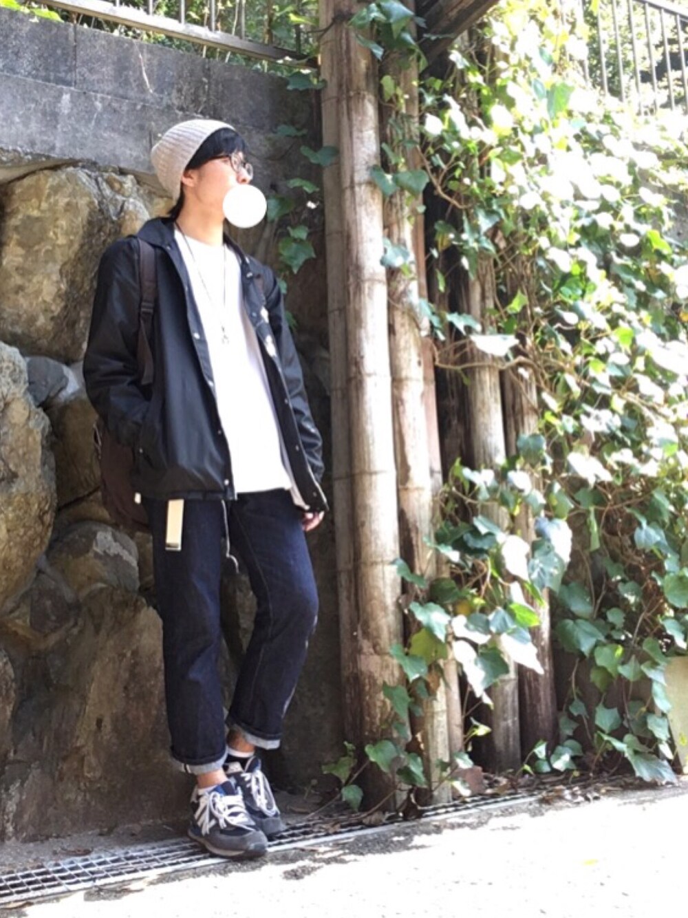 ブラック系のナイロンジャケット、ホワイト系のTシャツ/カットソー、ブルー系のスニーカーを着用したメンズの春コーディネートの1枚目の写真