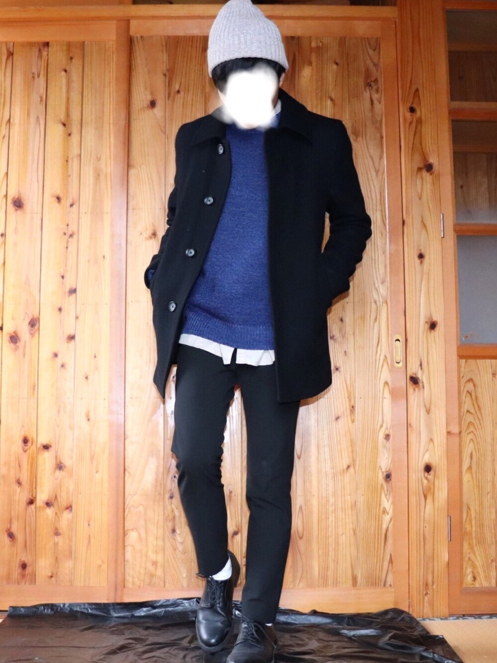 ブルー系のニット/セーター、ブラック系のステンカラーコート、ベージュ系のシャツ/ブラウスを着用したメンズの冬コーディネートの1枚目の写真