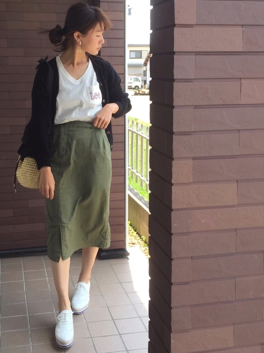 ピンク系のTシャツ/カットソー、ブラック系のニット/セーター、ブラック系のショルダーバッグを着用したレディースの春コーディネートの1枚目の写真