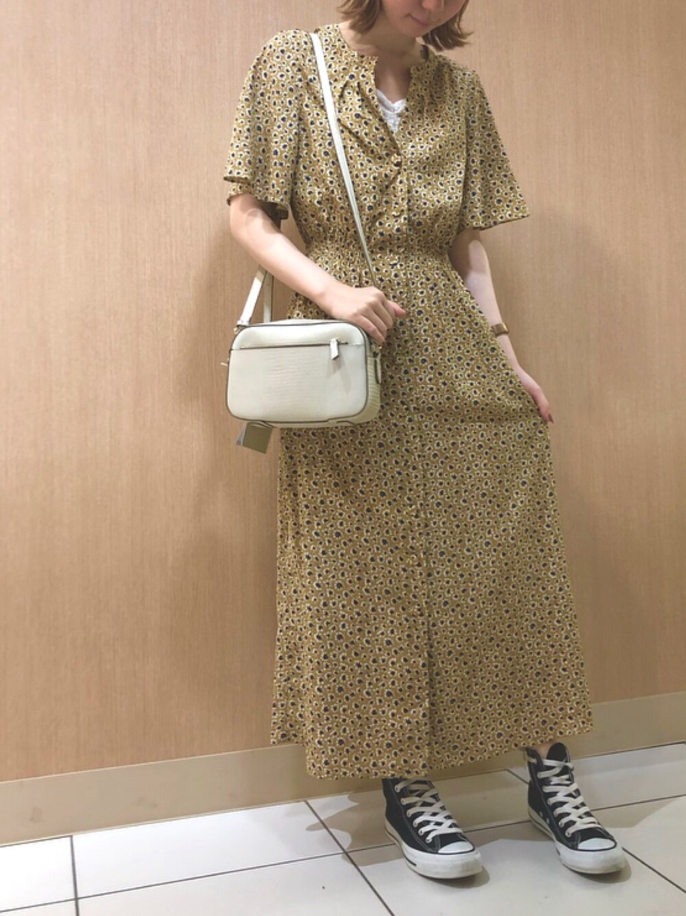 イエロー系のワンピース、ホワイト系のショルダーバッグを着用したレディースの夏コーディネートの1枚目の写真