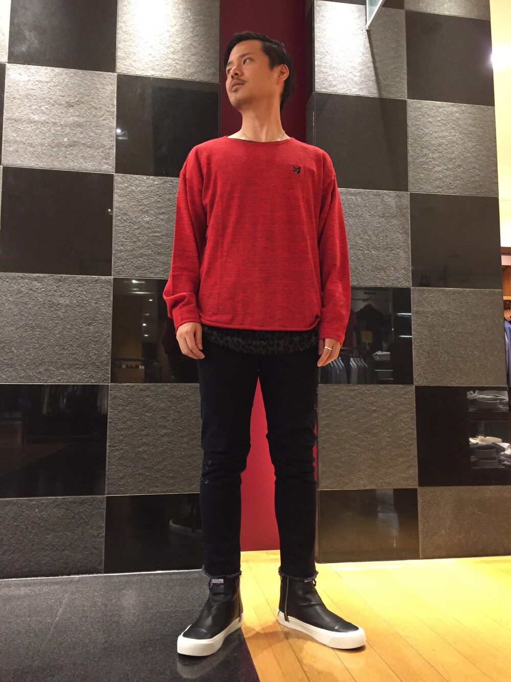 レッド系のニット/セーター、ブラック系のTシャツ/カットソー、ブラック系のデニムパンツを着用したメンズの夏コーディネートの1枚目の写真