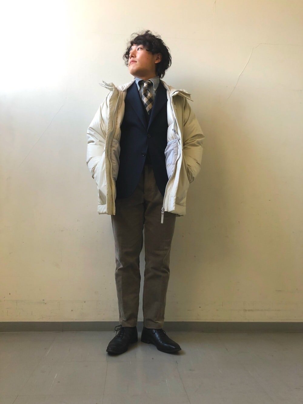 ホワイト系のダウンジャケット/コート、グレー系のその他パンツ、ブラック系のドレスシューズを着用したメンズの秋コーディネートの1枚目の写真