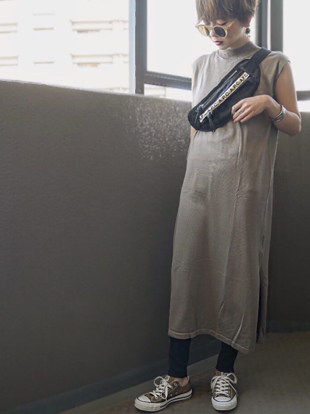 ベージュ系のワンピース、ブラウン系のスニーカー、ブラック系のボディバッグ/ウエストポーチを着用したレディースの春コーディネートの1枚目の写真