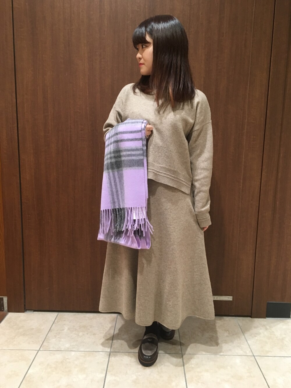 ベージュ系のワンピース、ブラウン系のローファー、その他のストール/ショールを着用したレディースの秋コーディネートの1枚目の写真