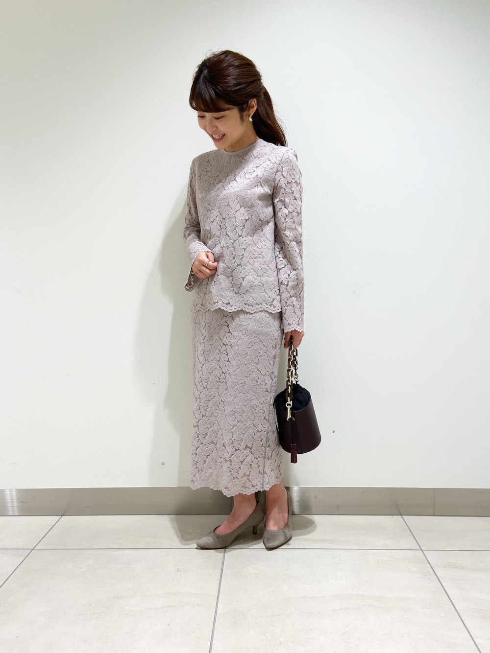 ベージュ系のシャツ/ブラウス、ベージュ系のスカート、レッド系のショルダーバッグを着用したレディースの冬コーディネートの1枚目の写真