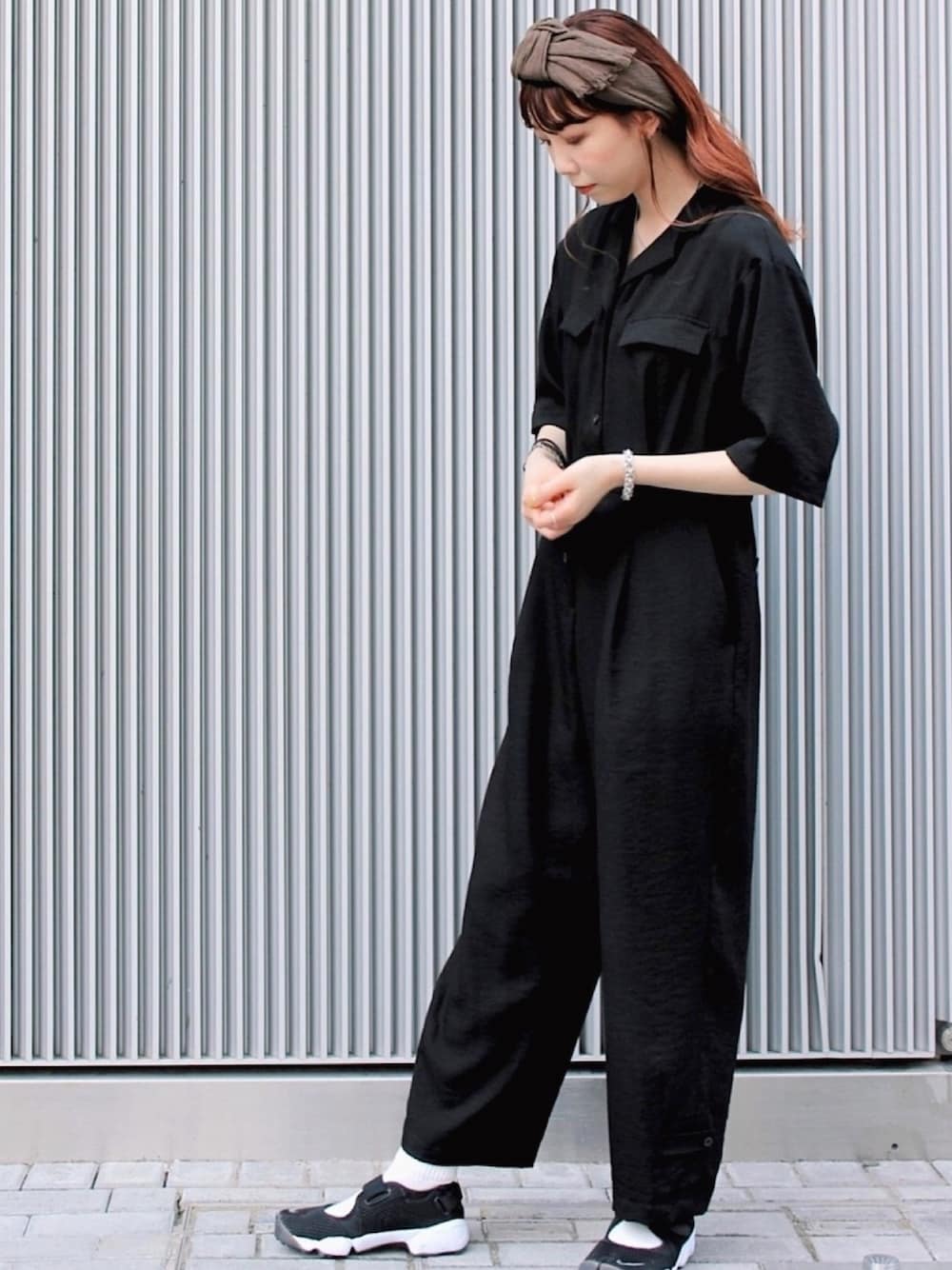 ブラック系のスニーカー、ブラウン系のヘアバンドを着用したレディースの秋コーディネートの1枚目の写真