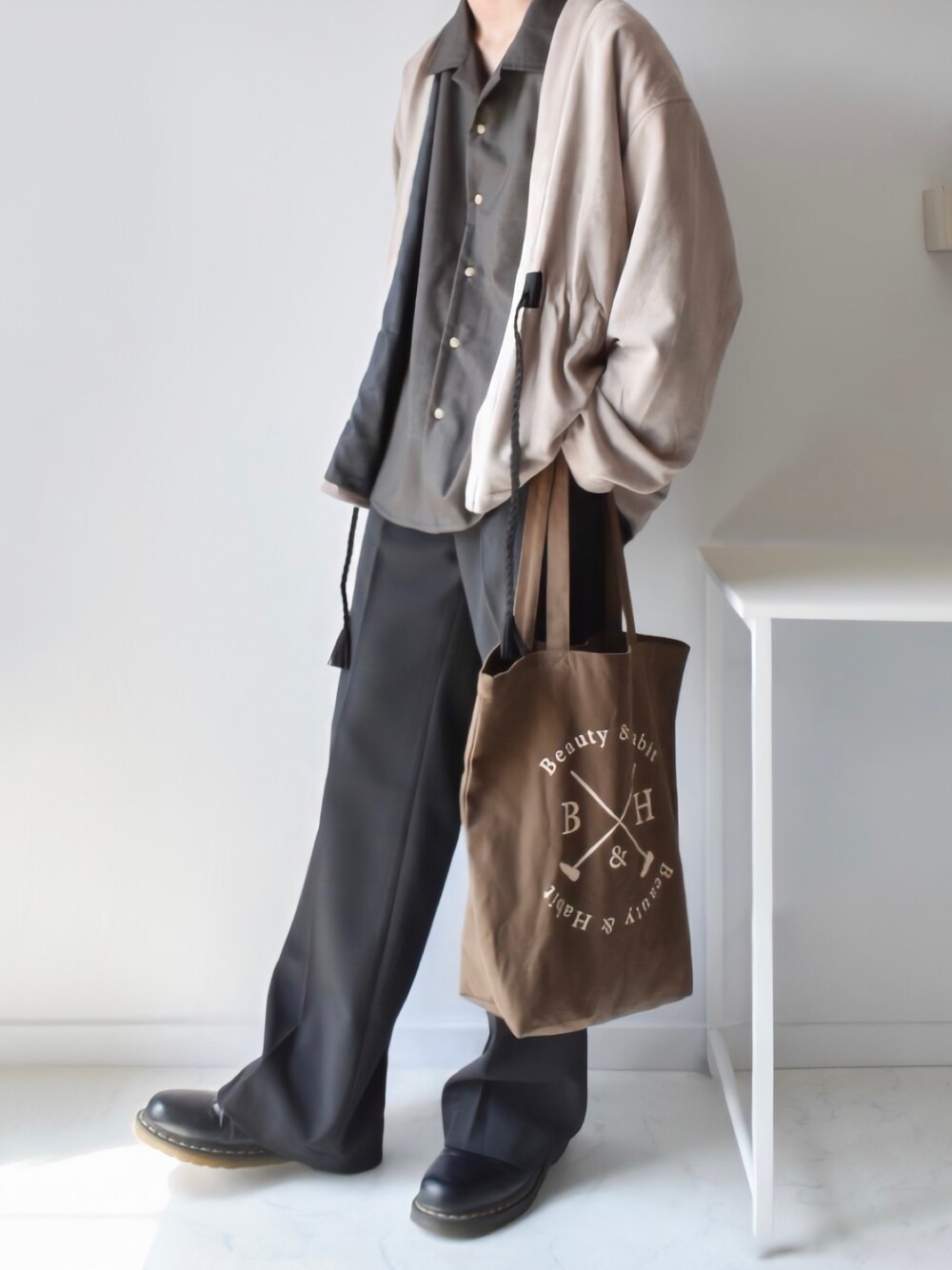 ベージュ系のカーディガン/ボレロ、ブラウン系のトートバッグ、ベージュ系のシャツ/ブラウスを着用したメンズの秋コーディネートの1枚目の写真