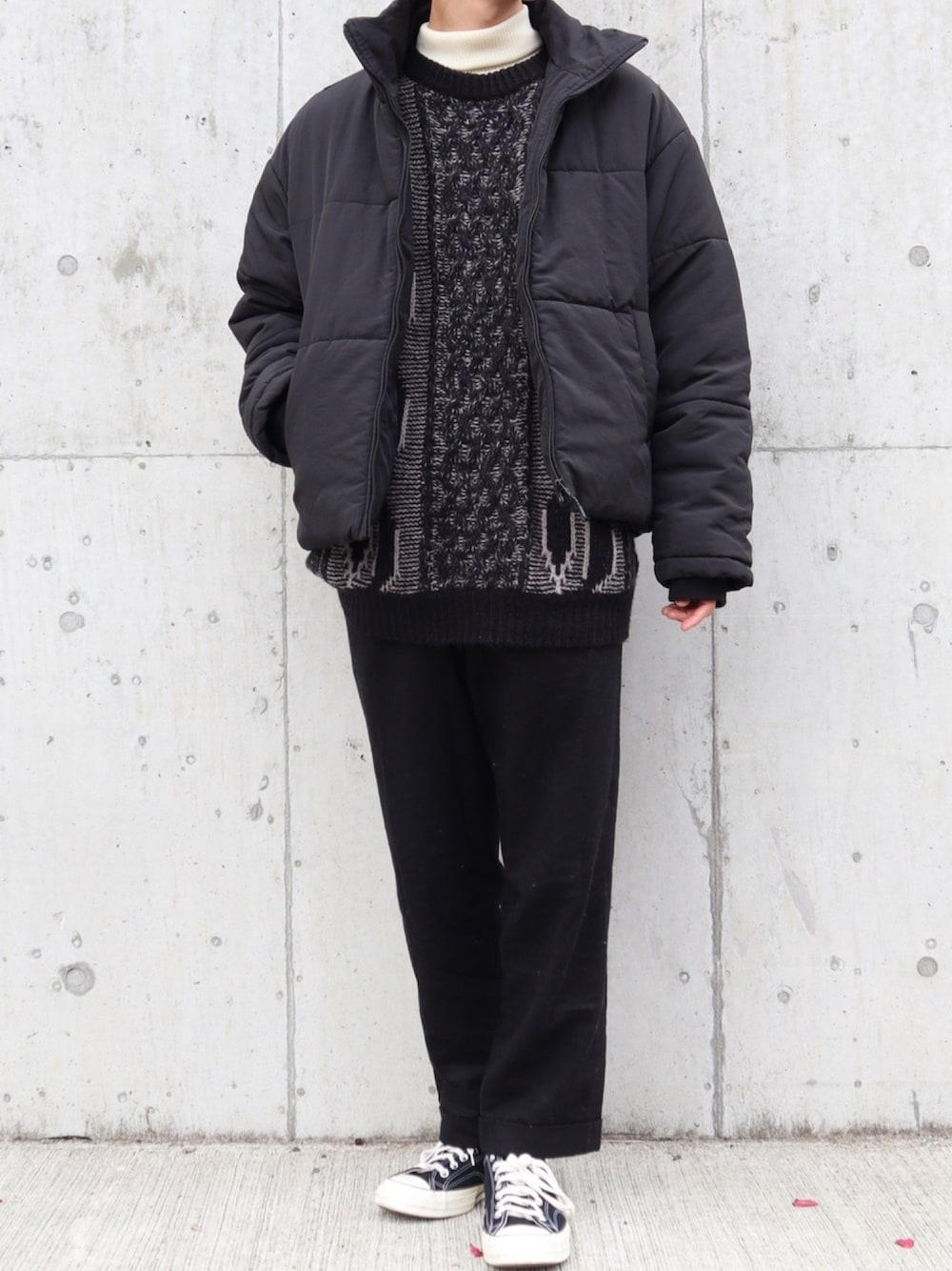 ブラック系のニット/セーター、ブラック系のその他アウター、ホワイト系のニット/セーターを着用したメンズの冬コーディネートの1枚目の写真