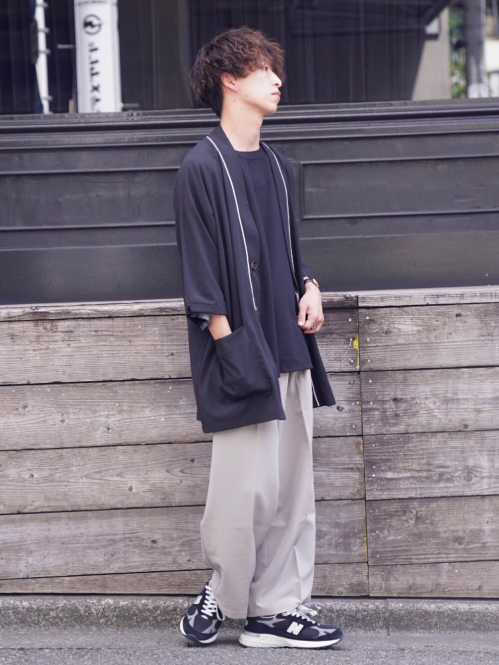 ブルー系のカーディガン/ボレロ、ブラック系のTシャツ/カットソー、グレー系のスラックスを着用したメンズの春コーディネートの1枚目の写真