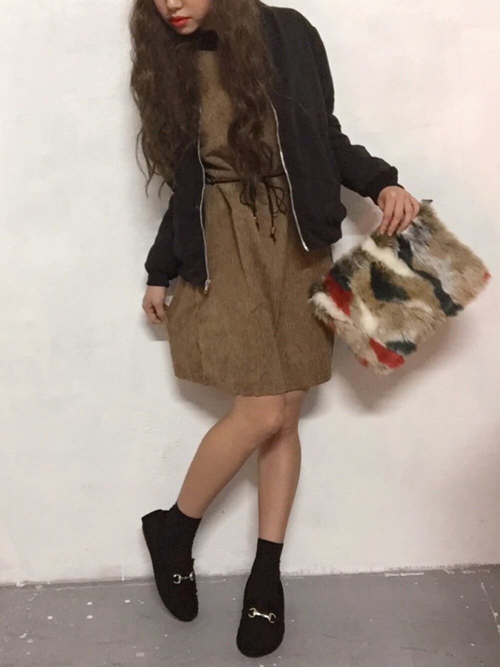 ベージュ系のワンピース、その他のクラッチバッグ、ブラック系のモカシン/デッキシューズを着用したレディースの冬コーディネートの1枚目の写真