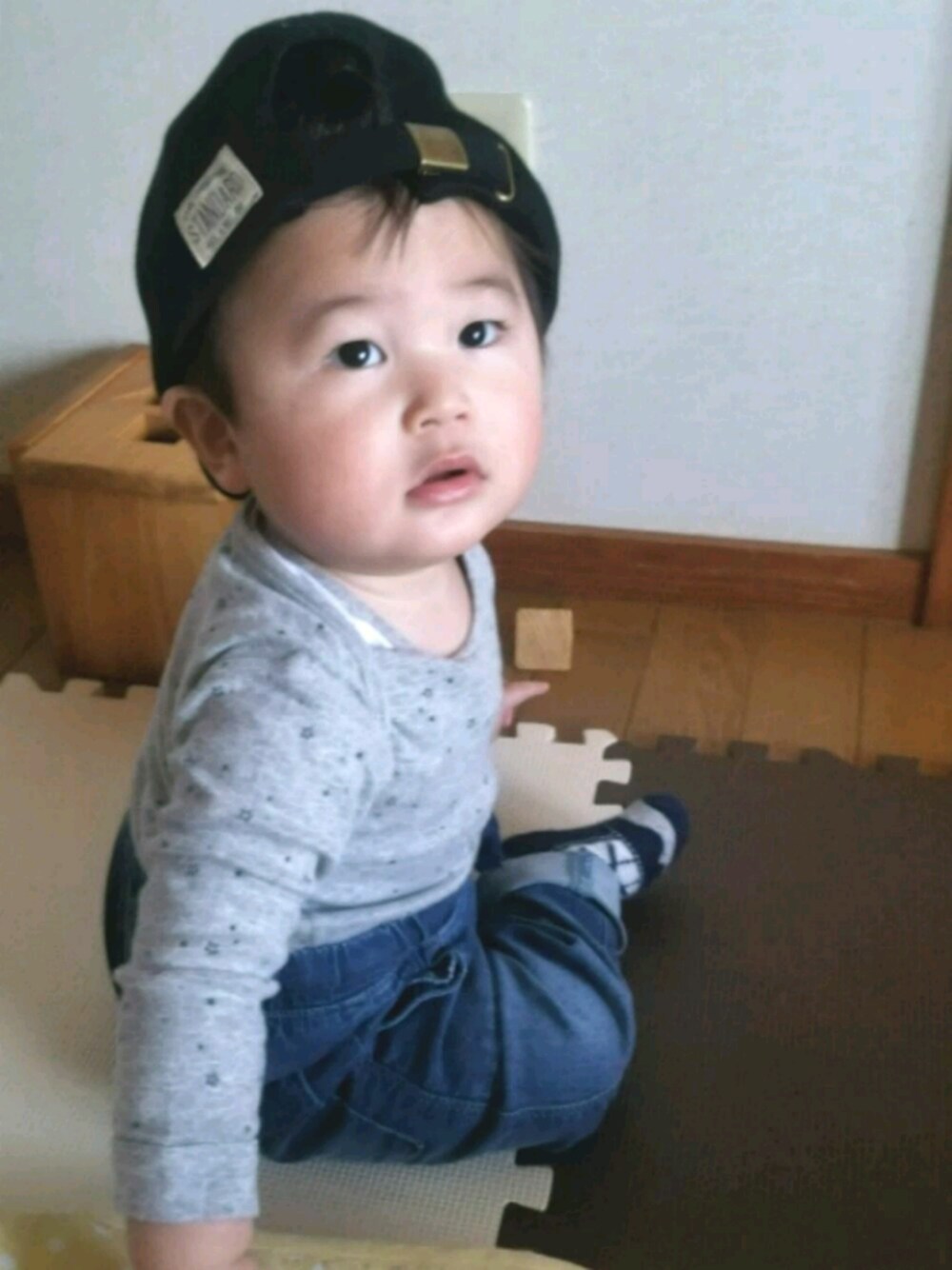 ブルー系のデニムパンツ、ブラック系のキャップを着用したキッズの春コーディネートの1枚目の写真