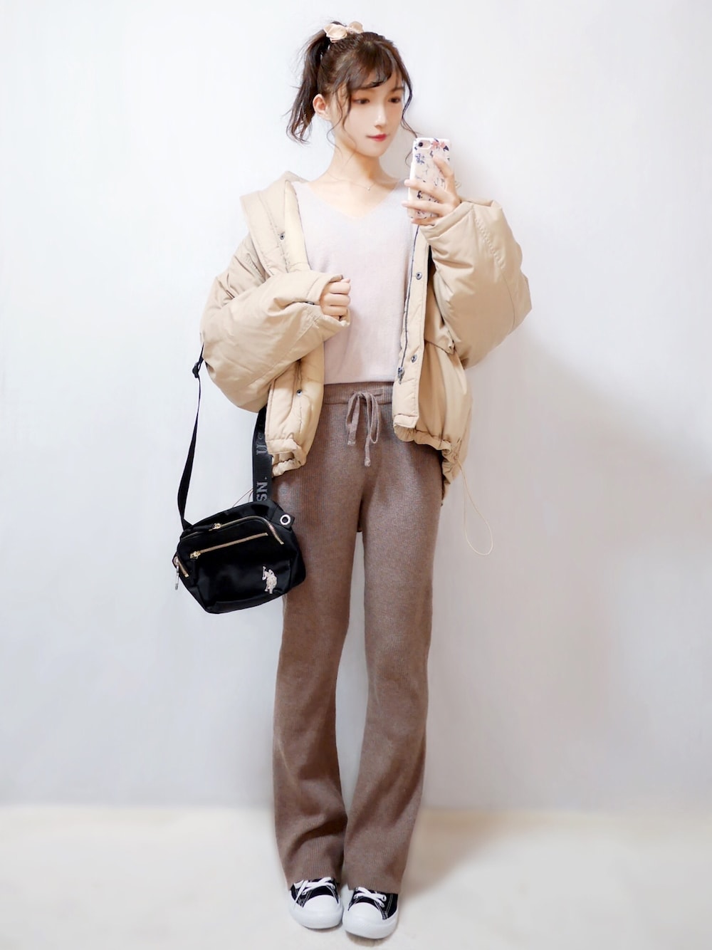 ベージュ系のダウンジャケット/コート、ピンク系のニット/セーター、ブラウン系のその他パンツを着用したレディースの冬コーディネートの1枚目の写真