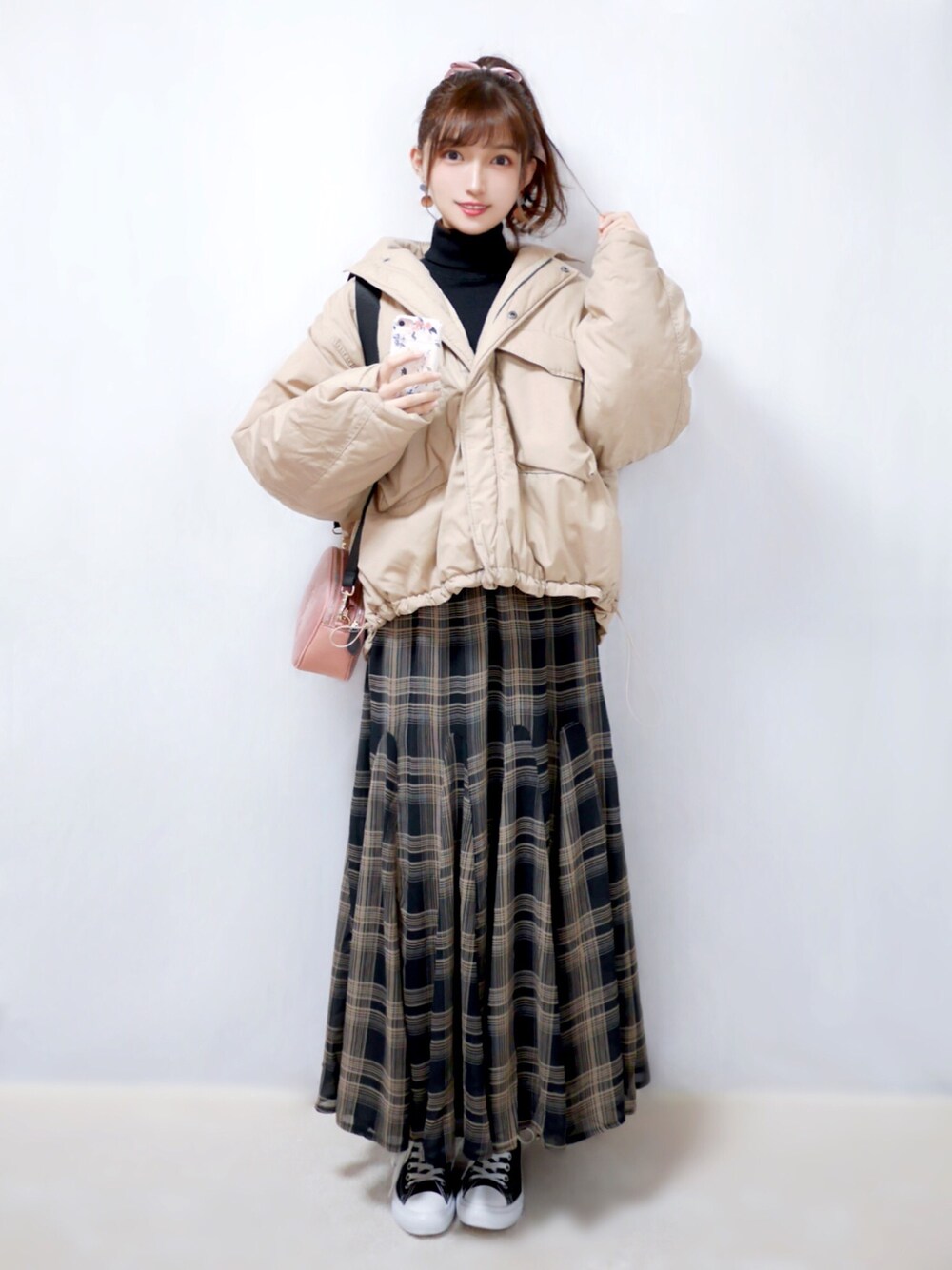 ベージュ系のダウンジャケット/コート、ブラック系のニット/セーター、ブラウン系のスカートを着用したレディースの冬コーディネートの1枚目の写真