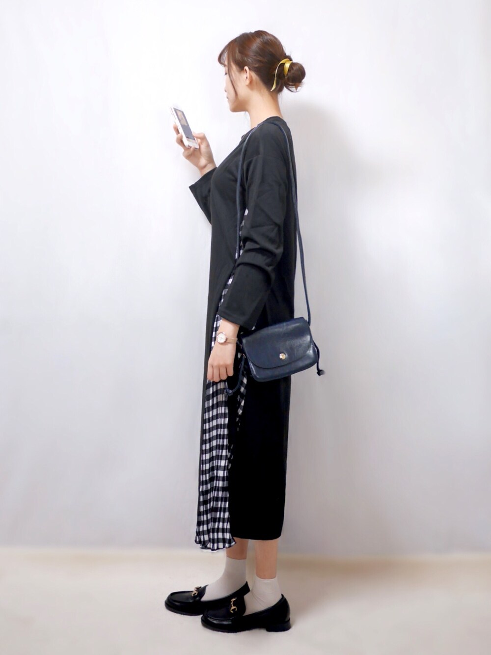 ブラック系のワンピース、ブルー系のショルダーバッグ、ブラック系のローファーを着用したレディースの春コーディネートの1枚目の写真