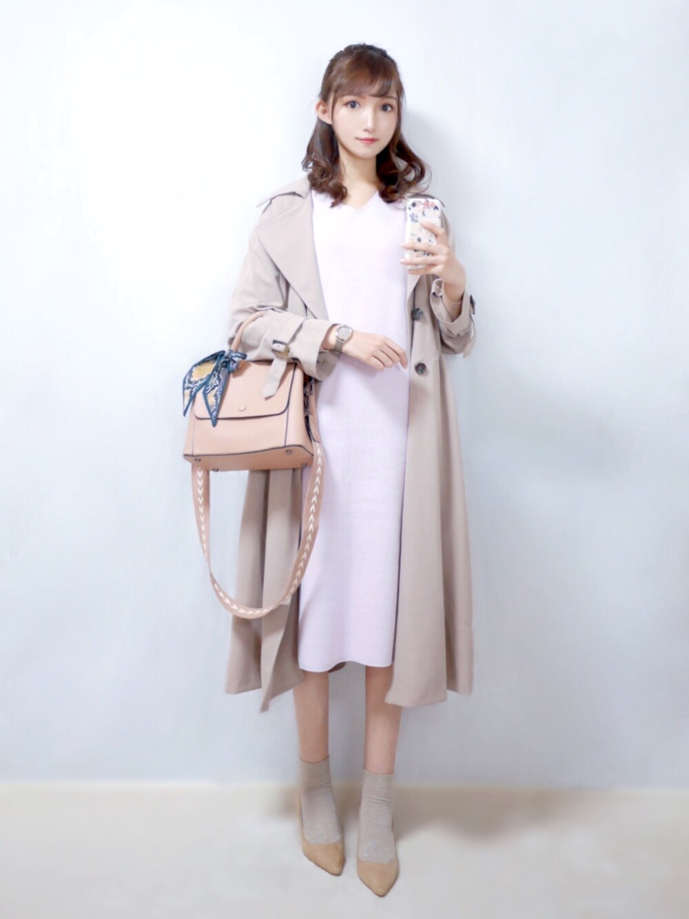 ピンク系のトレンチコート、パープル系のワンピース、ピンク系のショルダーバッグを着用したレディースの春コーディネートの1枚目の写真