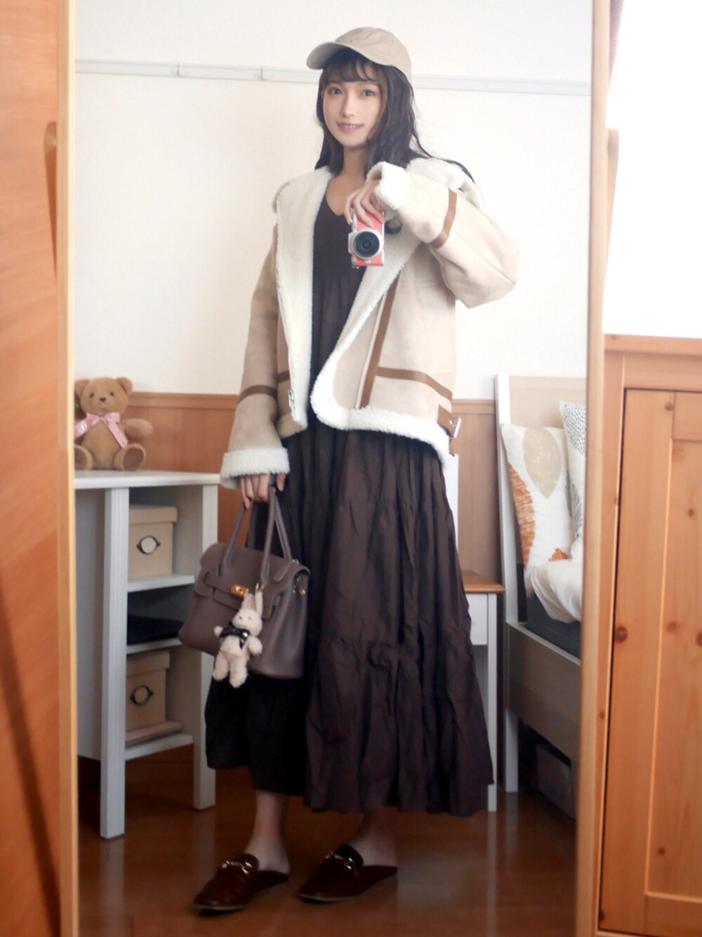 ホワイト系のブルゾン、ブラウン系のワンピース、パープル系のハンドバッグを着用したレディースの秋コーディネートの1枚目の写真