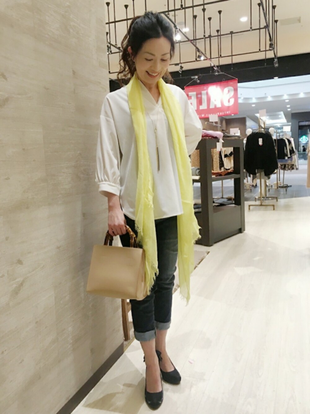 ベージュ系のショルダーバッグ、ホワイト系のシャツ/ブラウス、ブルー系のデニムパンツを着用したレディースの冬コーディネートの1枚目の写真