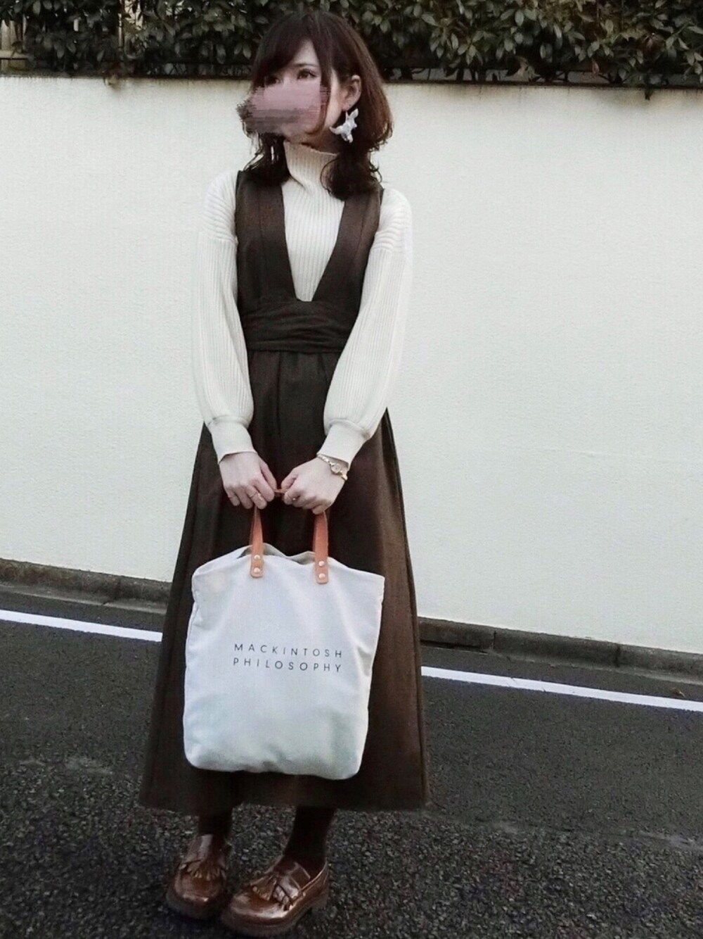 ベージュ系のニット/セーター、ブラウン系のワンピース、ブラウン系のシューズを着用したレディースの冬コーディネートの1枚目の写真