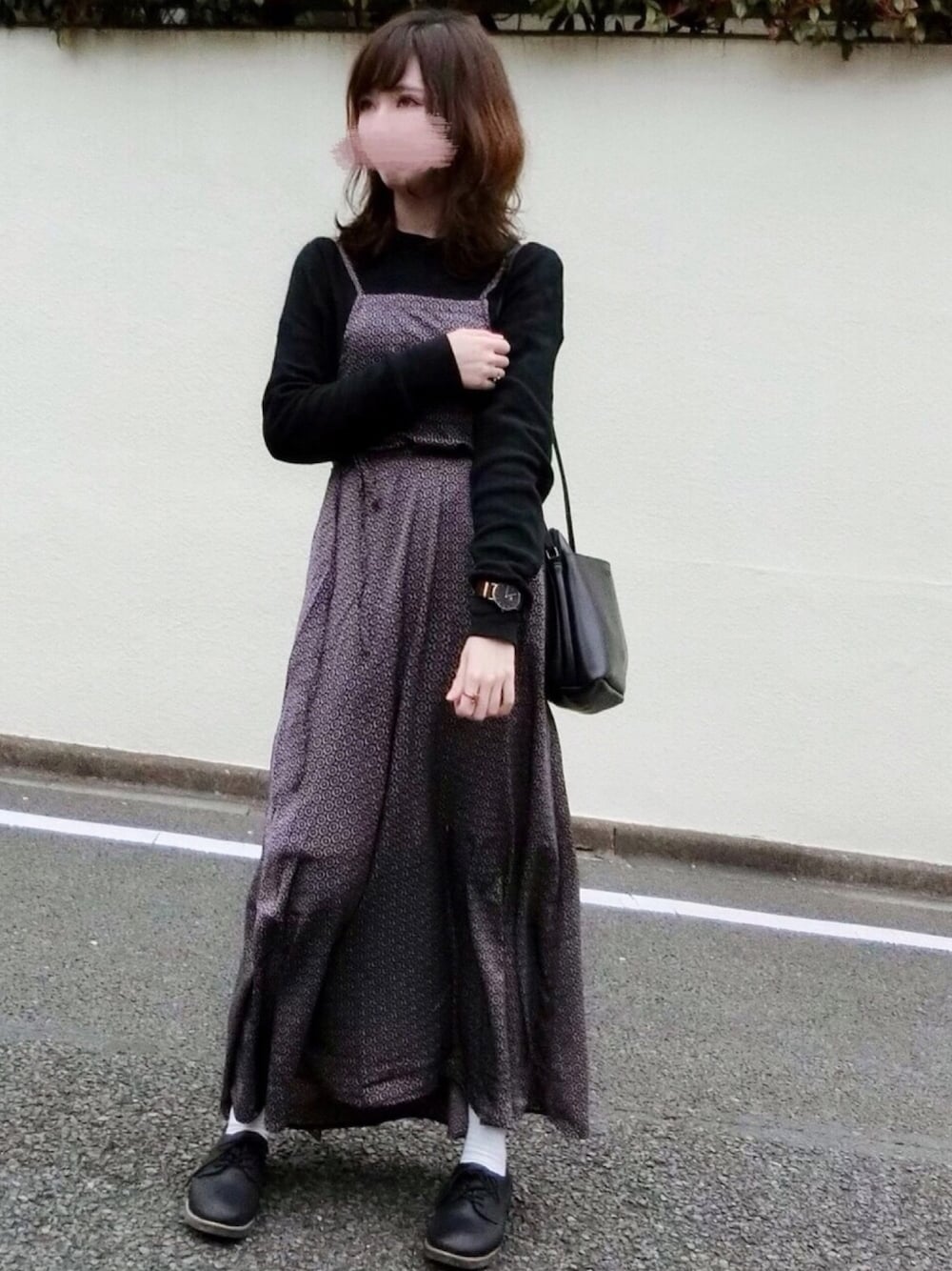 レッド系のワンピース、ブラック系のTシャツ/カットソー、ブラック系のショルダーバッグを着用したレディースの春コーディネートの1枚目の写真