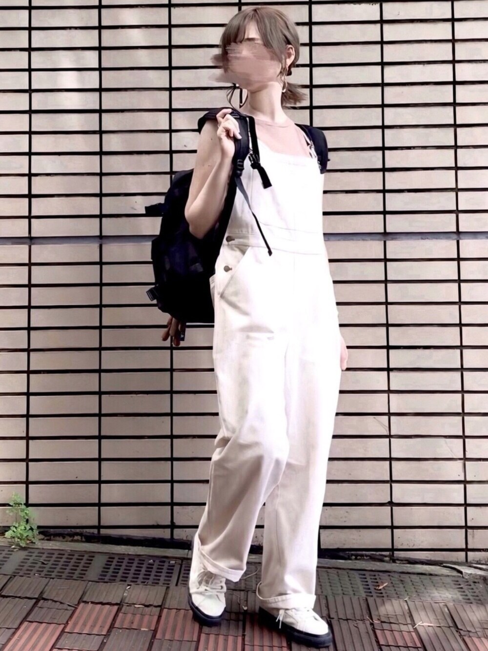 ホワイト系のサロペット/オーバーオール、ブラック系のバックパック/リュック、ホワイト系のスニーカーを着用したレディースの夏コーディネートの1枚目の写真