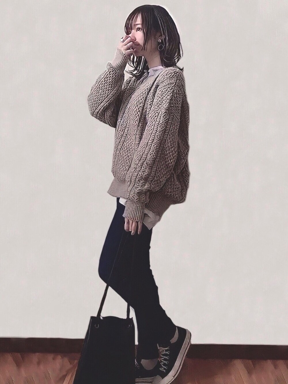 ベージュ系のニット/セーター、ブルー系のデニムパンツ、ブラック系のトートバッグを着用したレディースの秋コーディネートの1枚目の写真