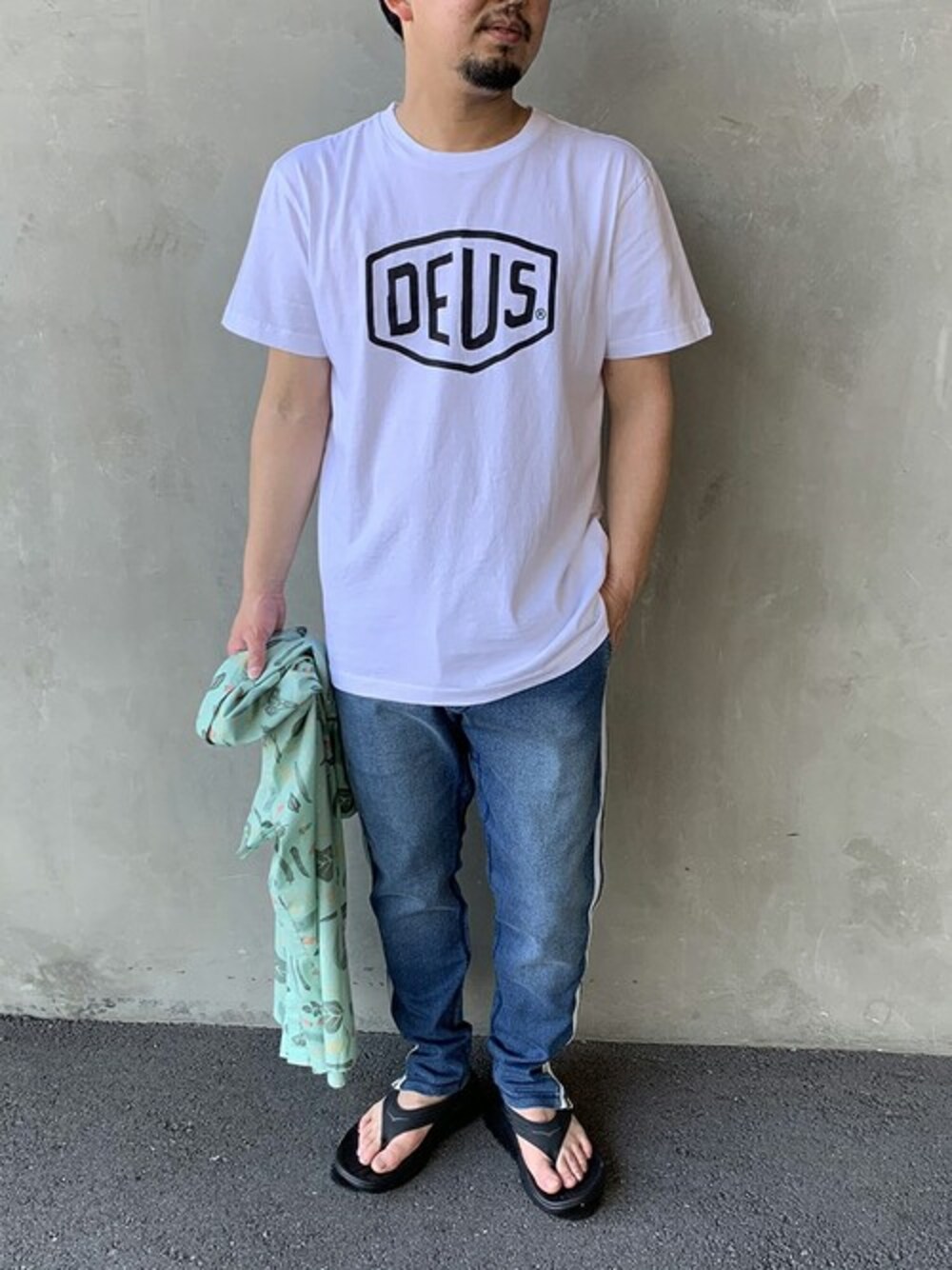 「ロゴT、柄シャツ、サーフ、サンダル、夏コーデ、デウス、Tシャツ×デニム、DEUS EX MACHINA、ラインパンツ、ジーンズファクトリー」｜「DEUS EX MACHINAの[DEUS EX MACHINA/デウス エクス マキナ] SHIELD シールドロゴプリントTシャツ（Tシャツ/カットソー、ホワイト系）」を使った、jeansfactoryさん（メンズ・166cm）の春コーディネートの1枚目の写真