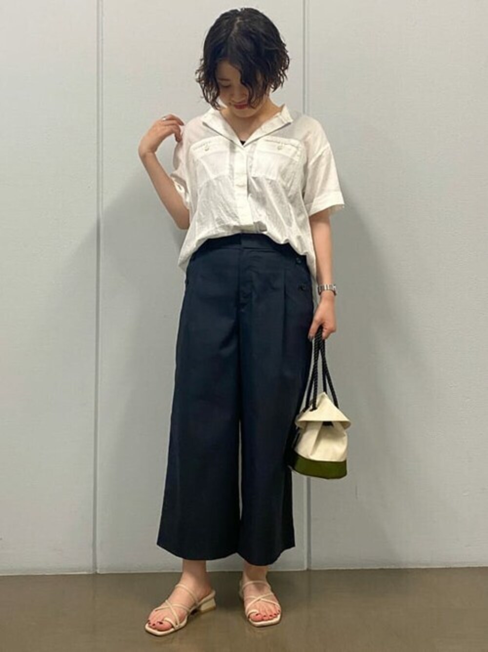 ホワイト系のシャツ/ブラウス、ブラック系のその他パンツ、グリーン系のハンドバッグを着用したレディースの夏コーディネートの1枚目の写真