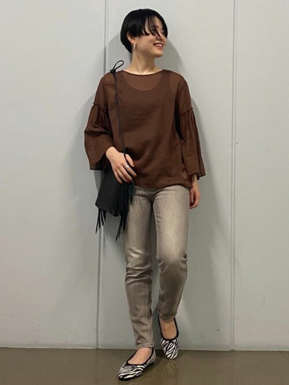 ブラウン系のシャツ/ブラウス、グレー系のデニムパンツ、ブラック系のハンドバッグを着用したレディースの秋コーディネートの1枚目の写真