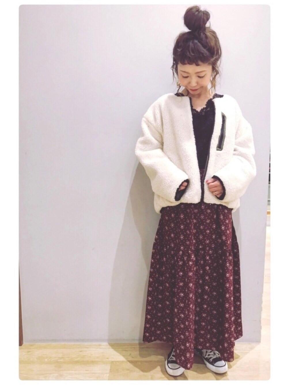 ブラック系のトップス、ホワイト系のその他アウター、レッド系のスカートを着用したレディースの秋コーディネートの1枚目の写真