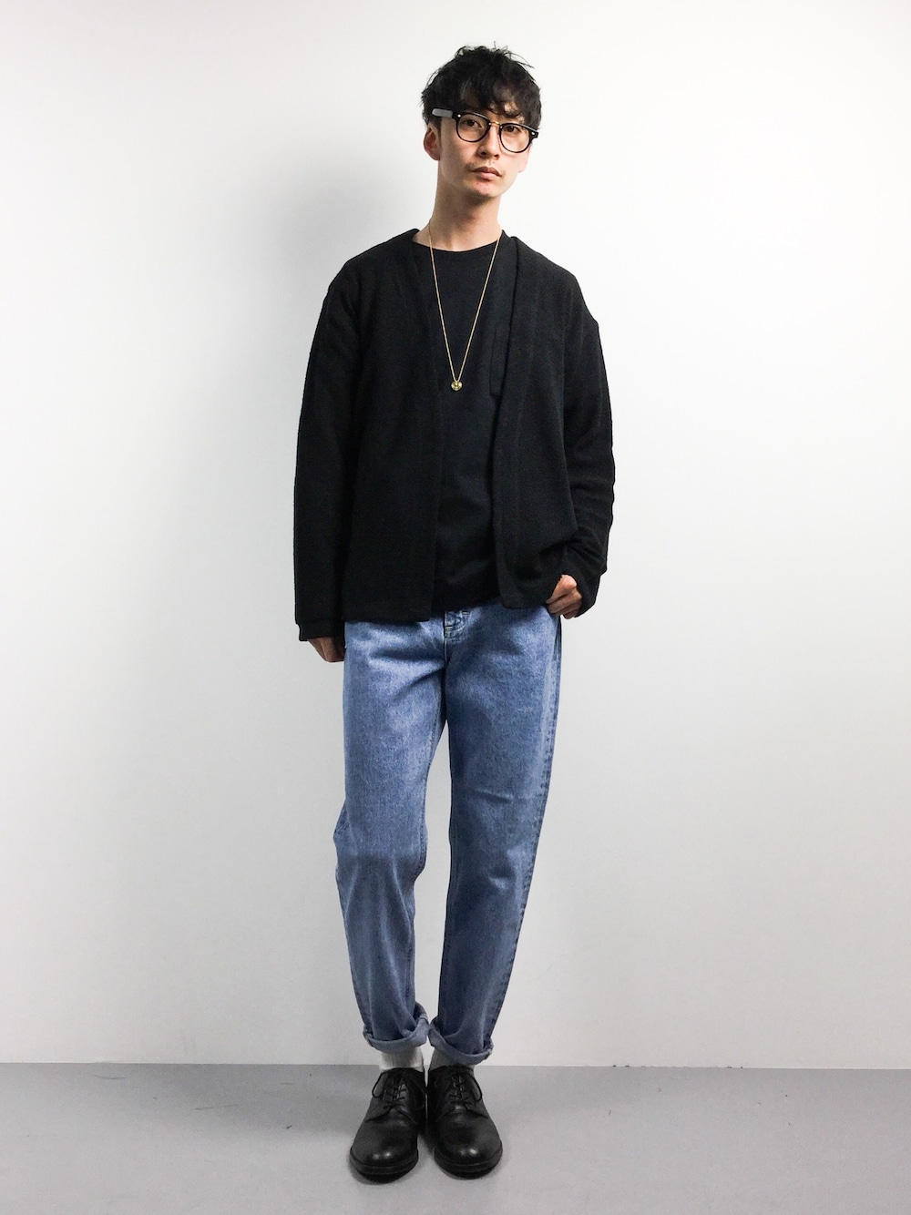 ブラック系のカーディガン/ボレロ、ブラック系のTシャツ/カットソー、ブルー系のデニムパンツを着用したメンズの春コーディネートの1枚目の写真
