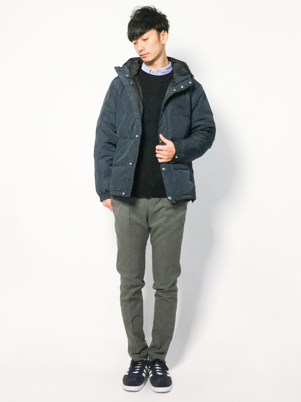 ブルー系のダウンジャケット/コート、ブラック系のニット/セーター、グレー系のスラックスを着用したメンズの冬コーディネートの1枚目の写真