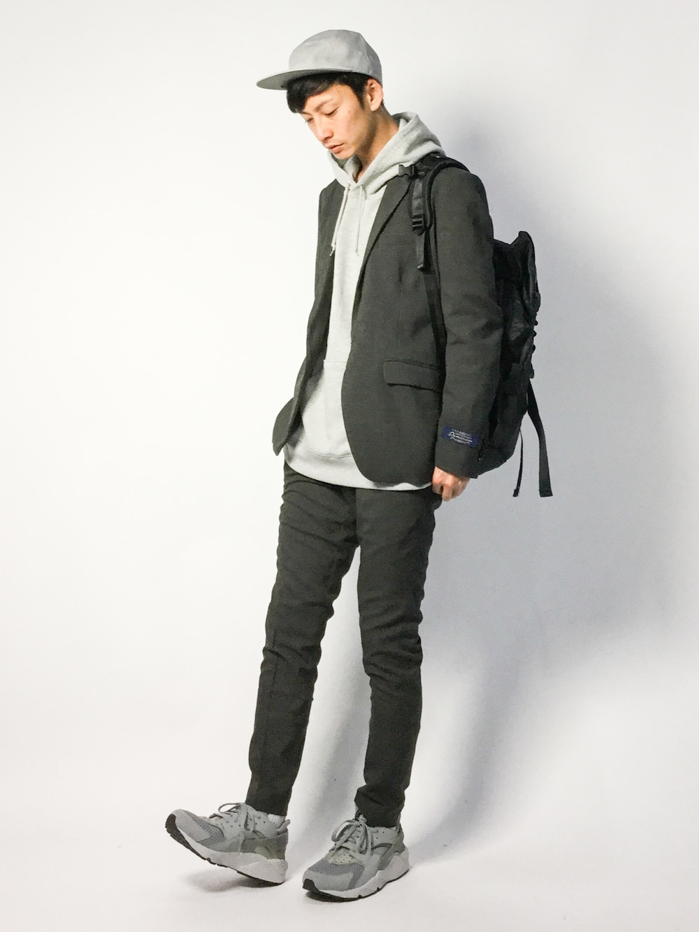 グレー系のテーラードジャケット、グレー系のパーカー、グレー系のスラックスを着用したメンズの春コーディネートの1枚目の写真