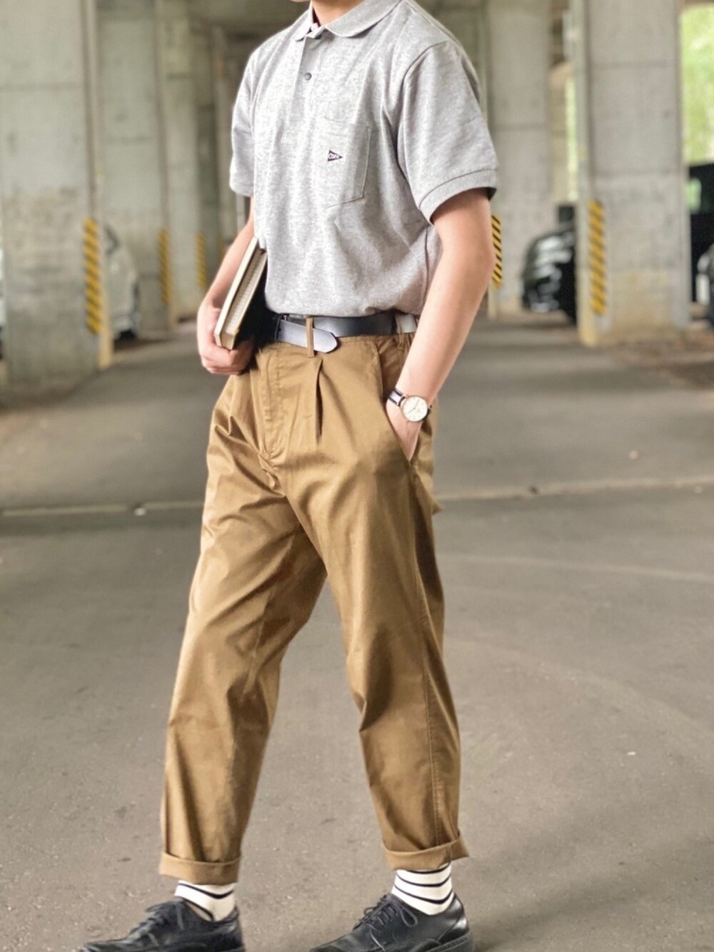 グレー系のポロシャツ、ベージュ系のその他パンツ、ブラック系のドレスシューズを着用したメンズの秋コーディネートの1枚目の写真