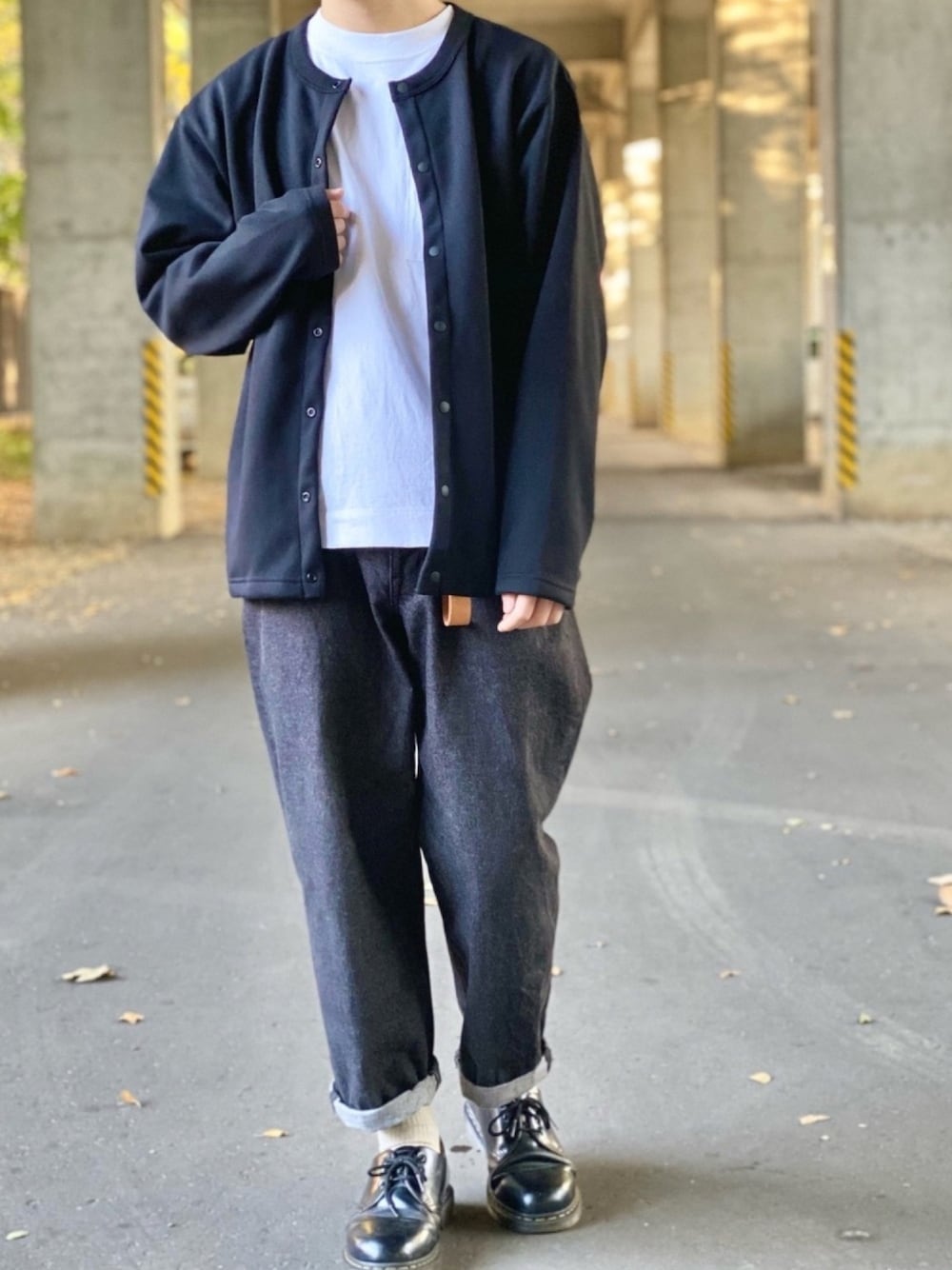 ブラック系のカーディガン/ボレロ、ホワイト系のTシャツ/カットソー、ブラック系のデニムパンツを着用したメンズの秋コーディネートの1枚目の写真