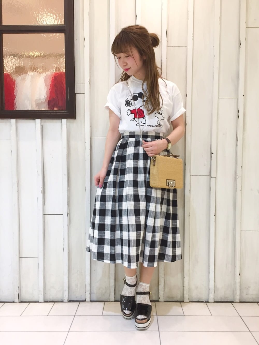 ブラック系のスカート、ブラウン系のショルダーバッグ、ブラック系のサンダルを着用したレディースの春コーディネートの1枚目の写真