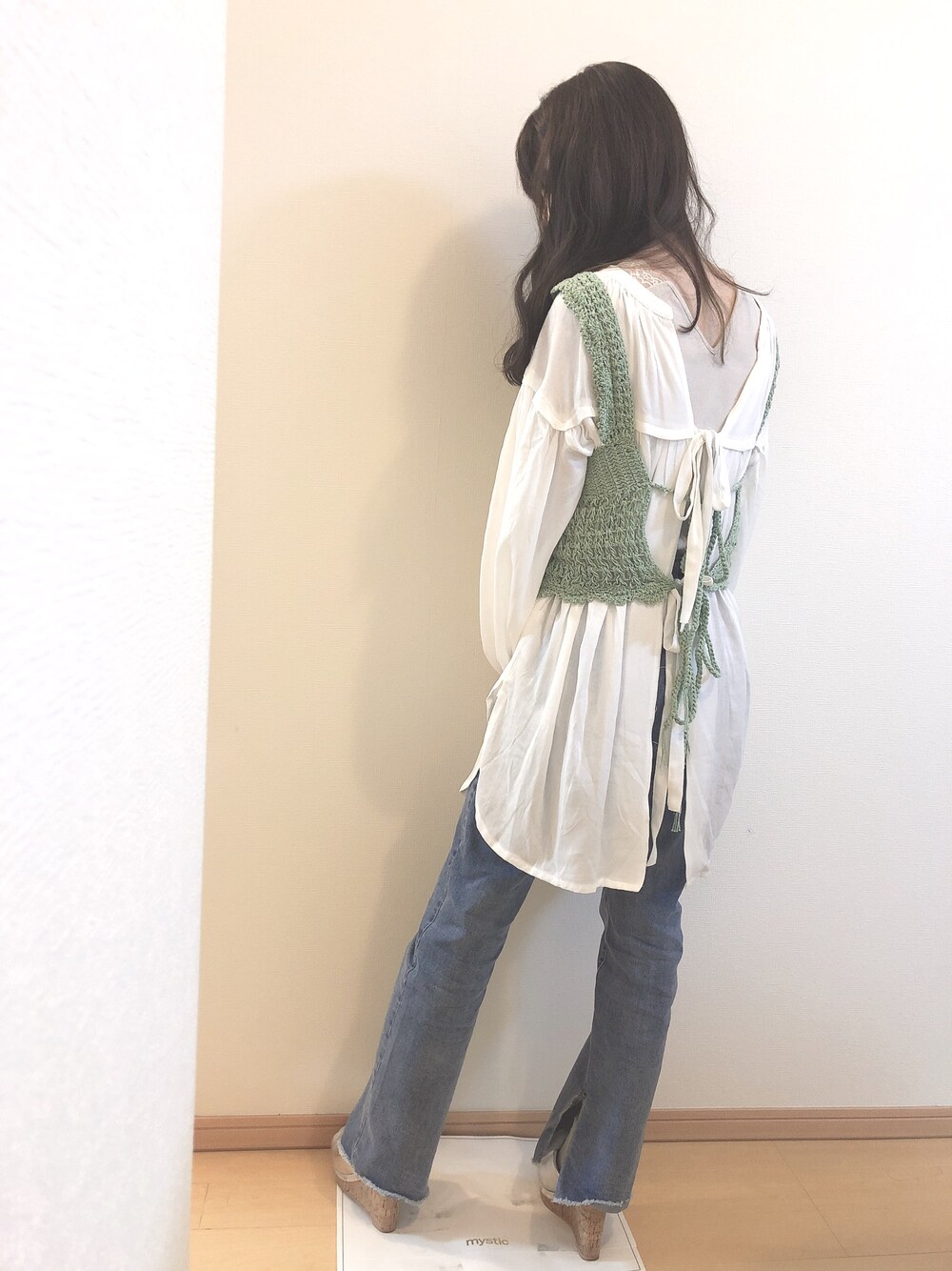 グリーン系のその他トップス、ホワイト系のシャツ/ブラウス、ブルー系のデニムパンツを着用したレディースの春コーディネートの1枚目の写真