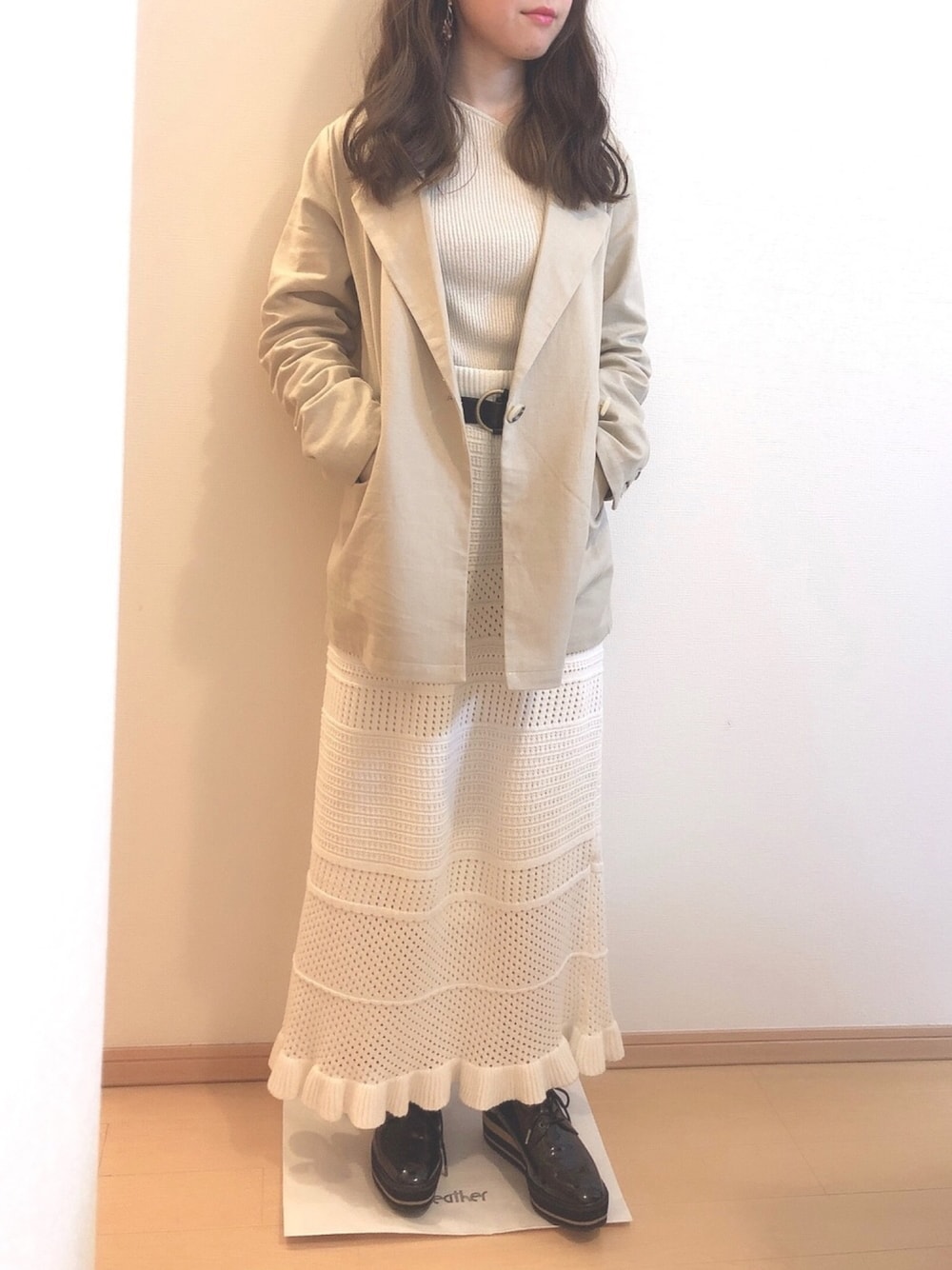 ホワイト系のニット/セーター、ベージュ系のテーラードジャケット、ホワイト系のスカートを着用したレディースの春コーディネートの1枚目の写真
