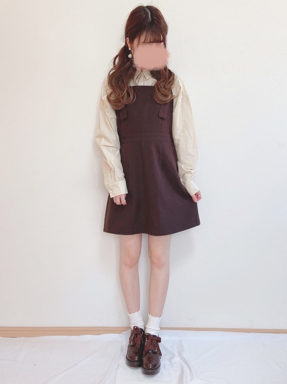 ベージュ系のシャツ/ブラウス、ブラウン系のジャンパースカート、ブラウン系のドレスシューズを着用したレディースの春コーディネートの1枚目の写真